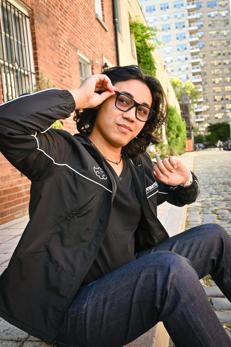 Alec Vogelsang, sitting on a kerb on a cobbled city street